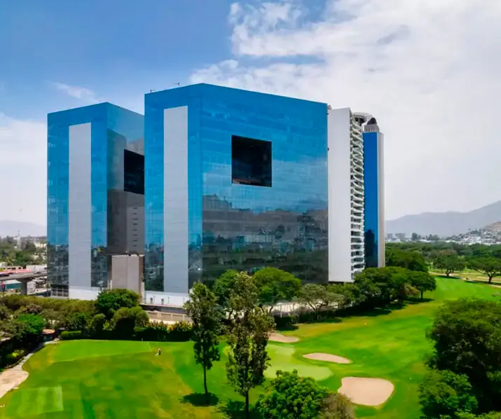 Imagen del moderno edificio de oficinas con fachada de vidrio y amplias áreas verdes en un campo de golf.