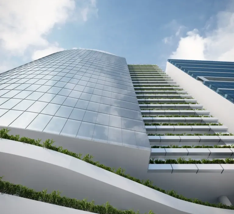 Rascacielos moderno con fachadas de vidrio y jardines en terrazas, bajo un cielo azul con nubes.