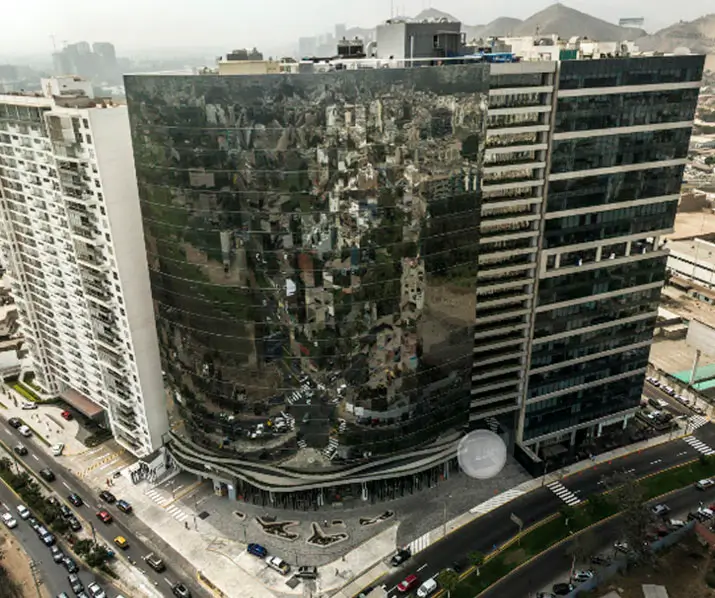 Edificio moderno con fachada reflectante que muestra el entorno urbano y tráfico en la ciudad. Ideal para arquitectura.