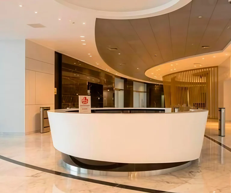 Recepción moderna con diseño curvo y acabados elegantes en un ambiente luminoso y acogedor.