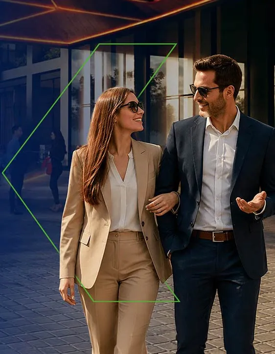 Pareja profesional sonriente paseando, vestidos elegantemente en un entorno urbano moderno. Imagen de confianza y estilo.