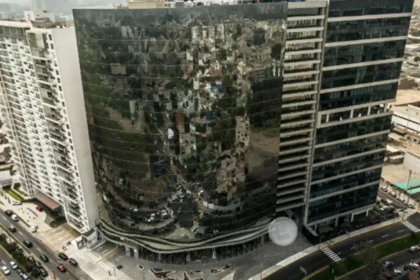 Edificio moderno con fachada reflectante que muestra el entorno urbano y tráfico en la ciudad. Ideal para arquitectura.