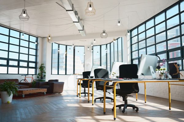 Oficina moderna con grandes ventanales, muebles minimalistas y luz natural, ideal para la productividad.